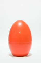 Red plastic egg on white table
