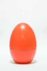 Foto auf Leinwand Red plastic egg on white table © nalinratphi