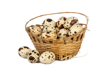 Obraz premium Quail eggs in an old basket, on a white background