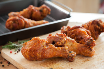 fried chicken with rosemary and pepper on chopping block