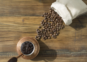 черный кофе в турке и зерна кофе, рассыпаны на деревянных досках