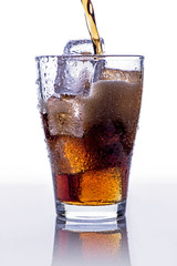Pooring soft drink in a glass with ice