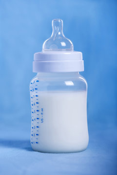 Baby milk bottle on a blue sheet