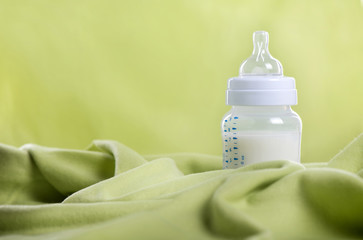 Baby milk bottle on a green sheet