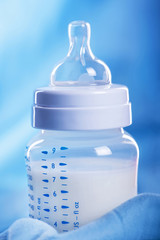 Baby milk bottle on a blue sheet