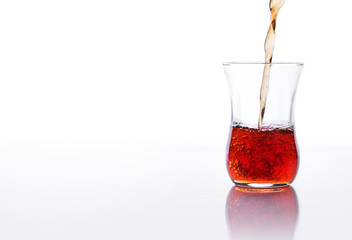 Fototapeta na wymiar Pouring red tea in a glass