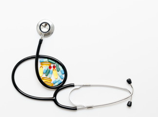 stethoscope on white background with pills