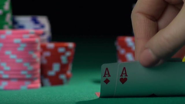 Poker player holding one pair of aces, good combination. Chances of winning