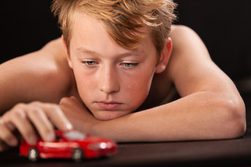 Young boy playing with a model car