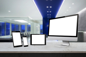 Responsive display devices on table in office. Isolated white screen for mockup presentation