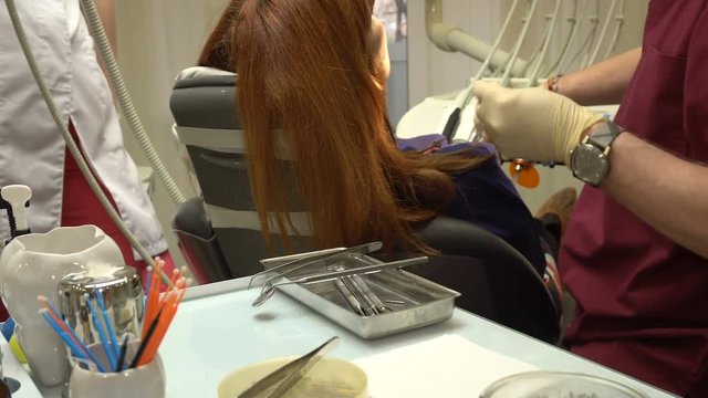 Young Woman in a Chair Dentist Dentistry Procedure, Doctor and Nurse at Work