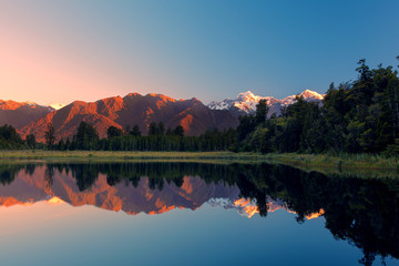 Twin Peaks reflect in the beautiful Lake Matheson at sunset, Southern Alps, South Island, New Zealand