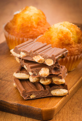 pieces of chocolate and muffins on wooden