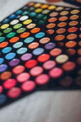 Multicolored eyeshadows on the wooden table