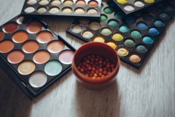 Multicolored eyeshadows on the wooden table