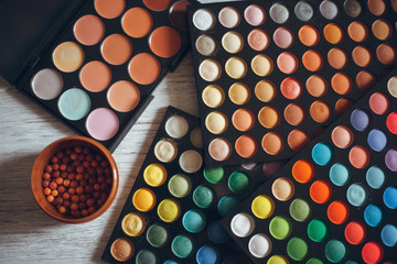 Multicolored eyeshadows on the wooden table
