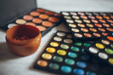 Multicolored eyeshadows on the wooden table