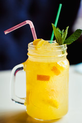 Preparation of the lemonade drink with tubes. Lemonade in the jug with lemons with mint on the table