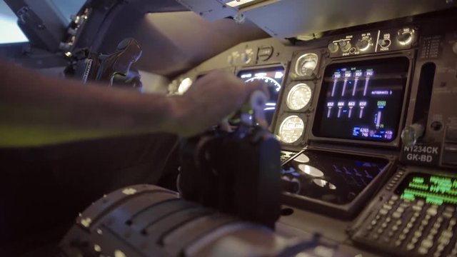 Detail shot of airline pilot pushing throttle forward and then pulling back in the cockpit of a jumbo jet.  Side view, hand-held camera, originally recorded in 4K.