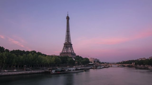 eiffel tower seen from a bridge on the seine river,timelapse from night to day,paris wakes up as the sun rise up 4k