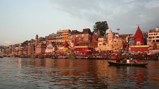 Holy city of Varanasi seen from Ganges river. Pan left.