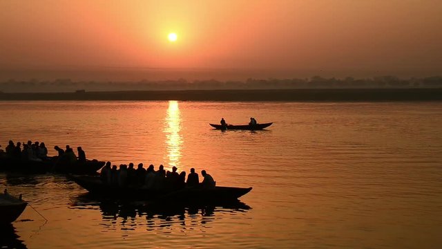 Boats sailing at holy Ganges river in Varanasi at sunrise.