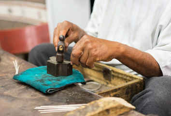 Silver master working with the hammer on silver in his workshop. Marocco's traditional style.