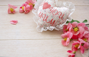 Textile handmade white heart with the inscription I love mum and red roses petals. A Happy Mother's Day theme.