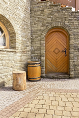Fototapeta premium Barrel and stump for chopping wood next to the house in a rustic style