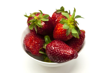 Fresh strawberries on a plate on white background