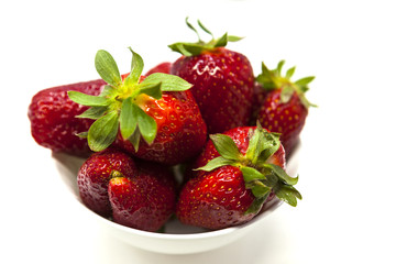 Fresh strawberries on a plate on white background