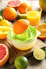 Citrus fruits with juicer on a grey wooden table