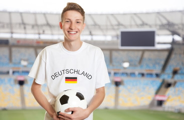 Fototapeta premium Deutscher Fussball Fan mit Ball im Stadion