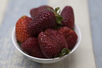 Fresh strawberry on a plate on a blue gray background