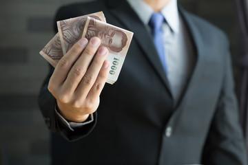Businessman holding money thai baht
