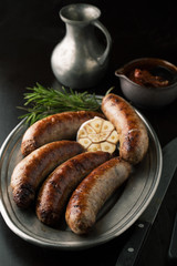 Grilled sausages on the grill with rosemary and garlic
