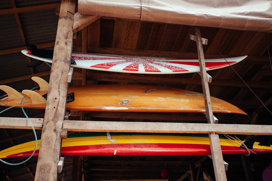 Set of different color surf boards in a stack by ocean.BALI. Sur