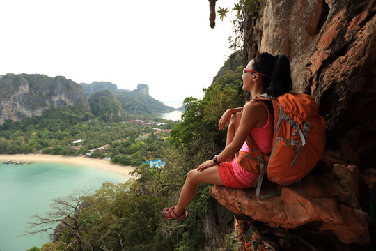 successful woman hiker enjoy the view on mountain top cliff