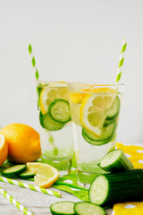 detox , healthy and refreshing drink ,Nutritious cold sparkling water with fresh green cucumber and yellow lemon on a wooden background