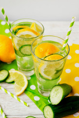 detox , healthy and refreshing drink ,Nutritious cold sparkling water with fresh green cucumber and yellow lemon on a wooden background