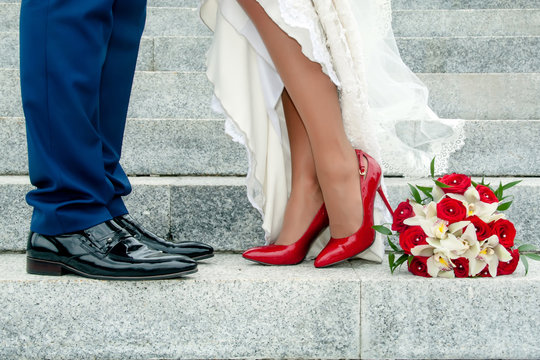Legs of wedding couple and bouquet
