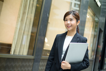 Businesswoman hold with laptop computer and walking at street