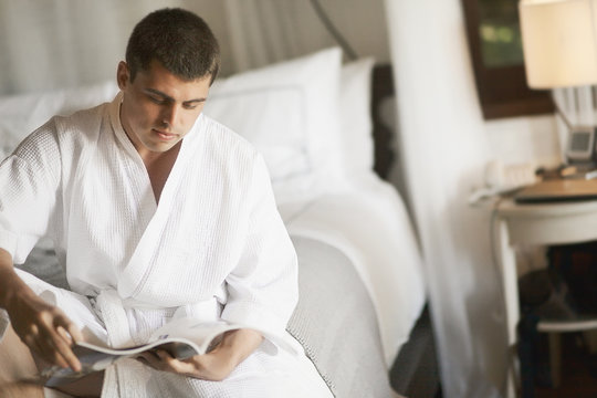 Gorgeous young man (gentleman) lying on a bed at the hotel.