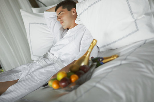 Gorgeous young man (gentleman) lying on a bed at the hotel.