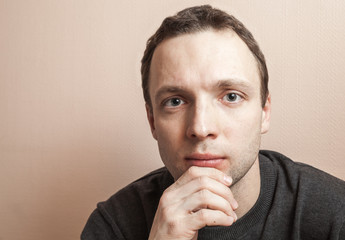 Young serious man, closeup studio portrait