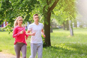 Fototapeta premium Man and woman jogging together in the park