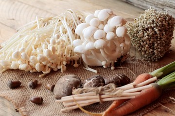 Mushrooms and vegetables on wood background.