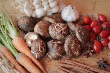 Mushrooms and vegetables on wood background.