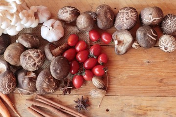 Mushrooms and vegetables on wood background.