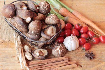 Mushrooms and vegetables on wood background.